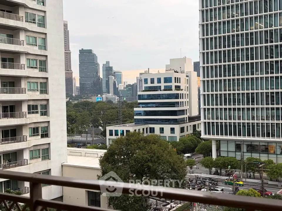 Stunning urban view from a high-rise balcony overlooking city skyline and modern architecture.