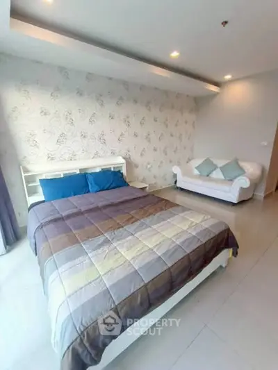 Spacious bedroom with modern decor and cozy seating area