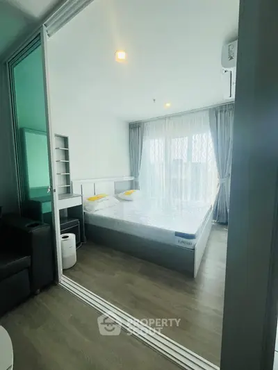Modern bedroom with large windows and stylish decor in a contemporary apartment.