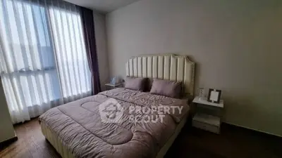 Cozy bedroom with elegant decor and large window for natural light.