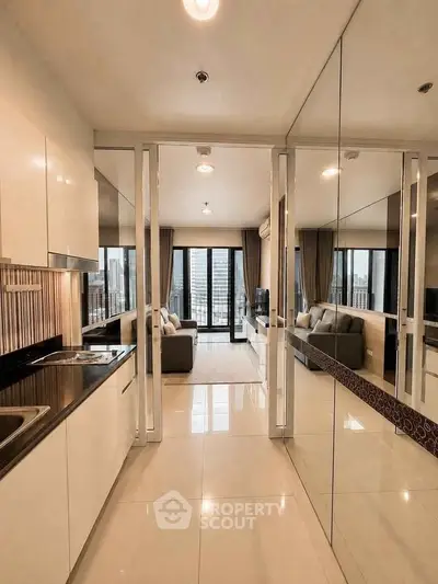 Modern open-layout kitchen leading to a stylish living room with city view.