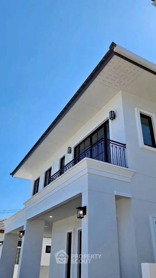 Modern two-story house with elegant balcony and sleek exterior design.