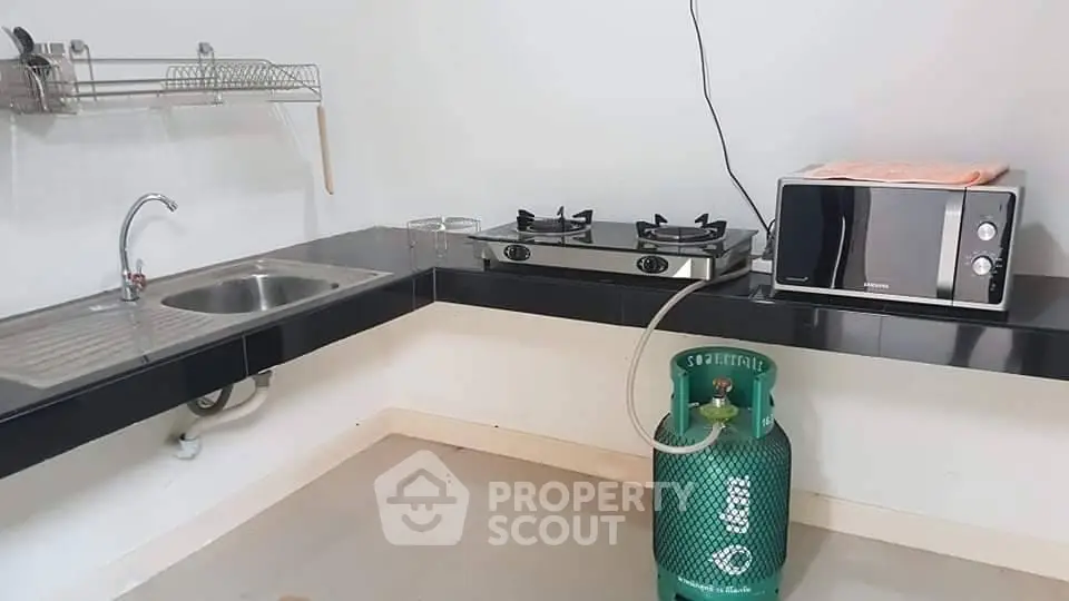 Modern kitchen with gas stove, microwave, and sleek countertops in a contemporary home.