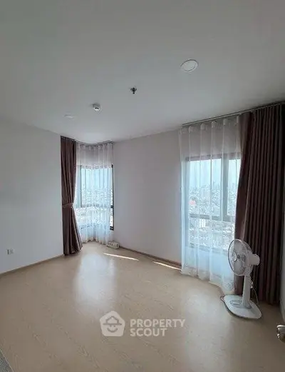 Spacious empty room with large windows and city view, perfect for customization.