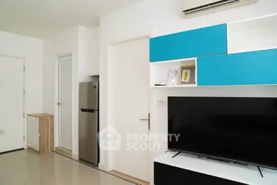 Modern living room with sleek design, featuring a flat-screen TV, air conditioning, and stylish blue cabinetry.