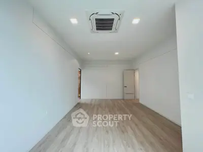 Spacious unfurnished room with modern ceiling air conditioning and wooden flooring.