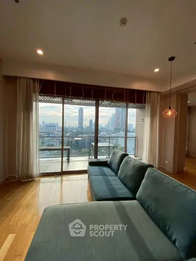 Spacious living room with large windows offering stunning city view and cozy seating area.