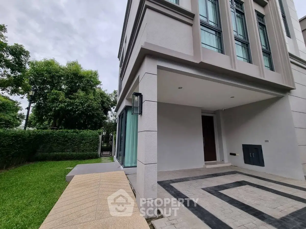 Modern townhouse exterior with lush green garden and stylish entrance