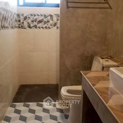 Modern bathroom with geometric tile design and sleek fixtures.