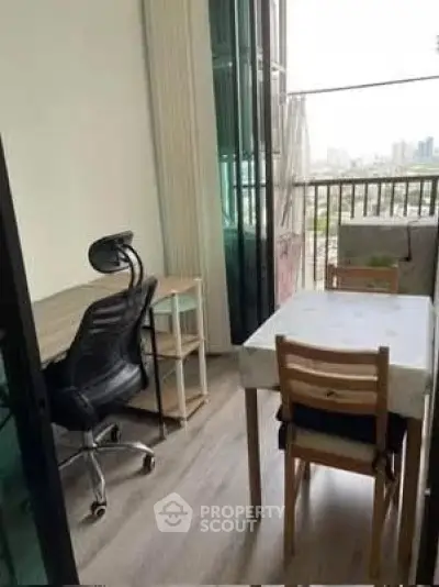 Charming study area with city view and balcony access, perfect for work-from-home setup.