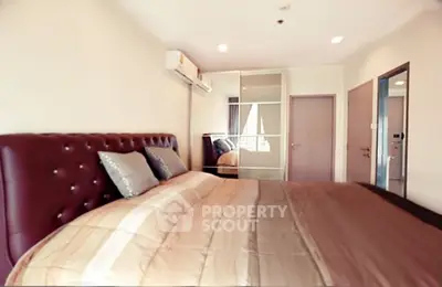Spacious bedroom with modern decor and mirrored closet doors in a stylish apartment.