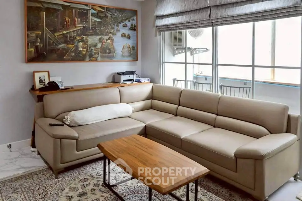 Stylish living room with modern sectional sofa and large window offering natural light.