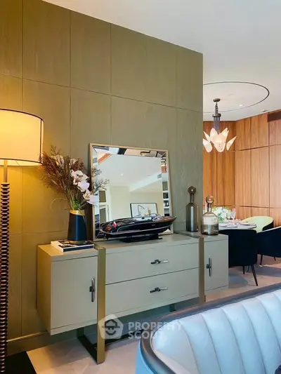 Elegant living room with modern decor and stylish furniture, featuring a chic dining area in the background.