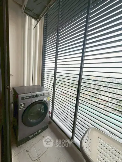 High-rise apartment balcony with washing machine and city view