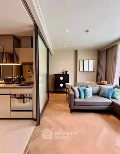 Modern living room with sleek kitchen and stylish decor in open layout apartment.