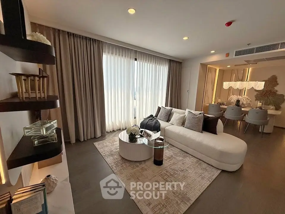 Luxurious living room with elegant decor and dining area, featuring modern furniture and ambient lighting.