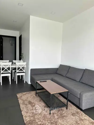Modern living room with sleek gray sofa and dining area, perfect for contemporary living.