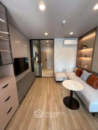 Modern living room with sleek design, featuring a cozy sofa, stylish shelving, and a flat-screen TV.