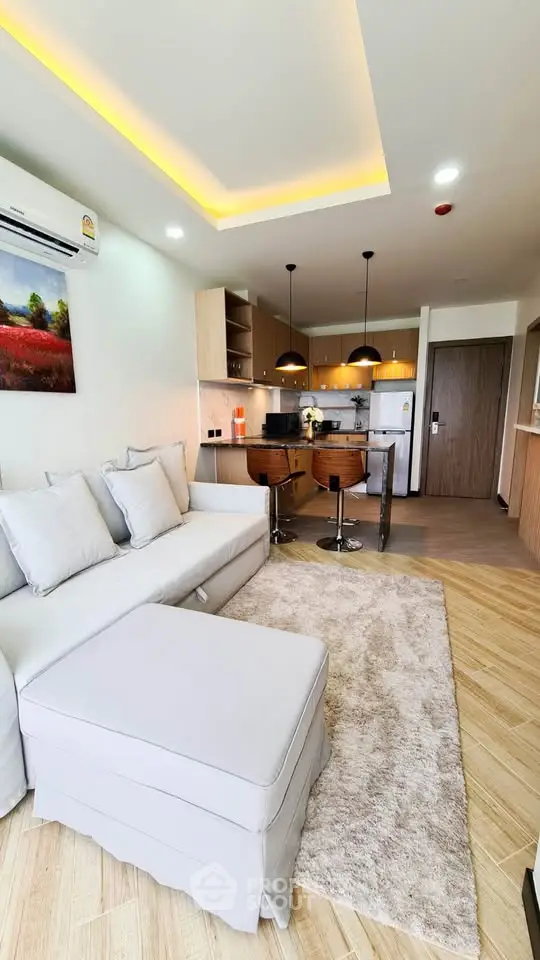 Modern open-plan living room with stylish kitchen and cozy seating area, perfect for urban living.
