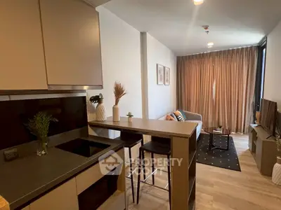Modern open-layout kitchen and living room with stylish decor and natural light.