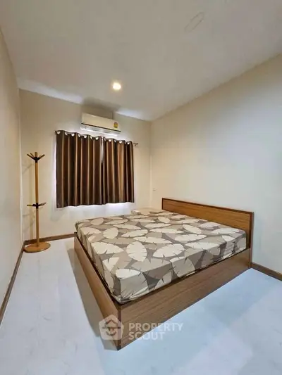 Spacious bedroom with modern decor and natural light, featuring a stylish bed and elegant curtains.