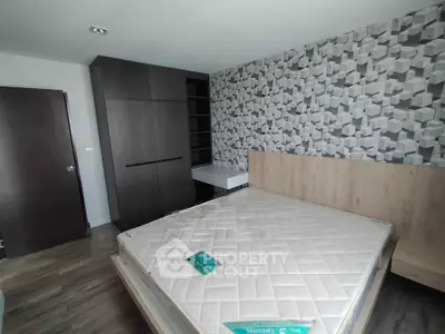 Modern bedroom with stylish geometric wallpaper and sleek dark wardrobe