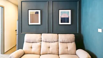 Stylish living room with modern art and cozy beige sofa, perfect for relaxation.
