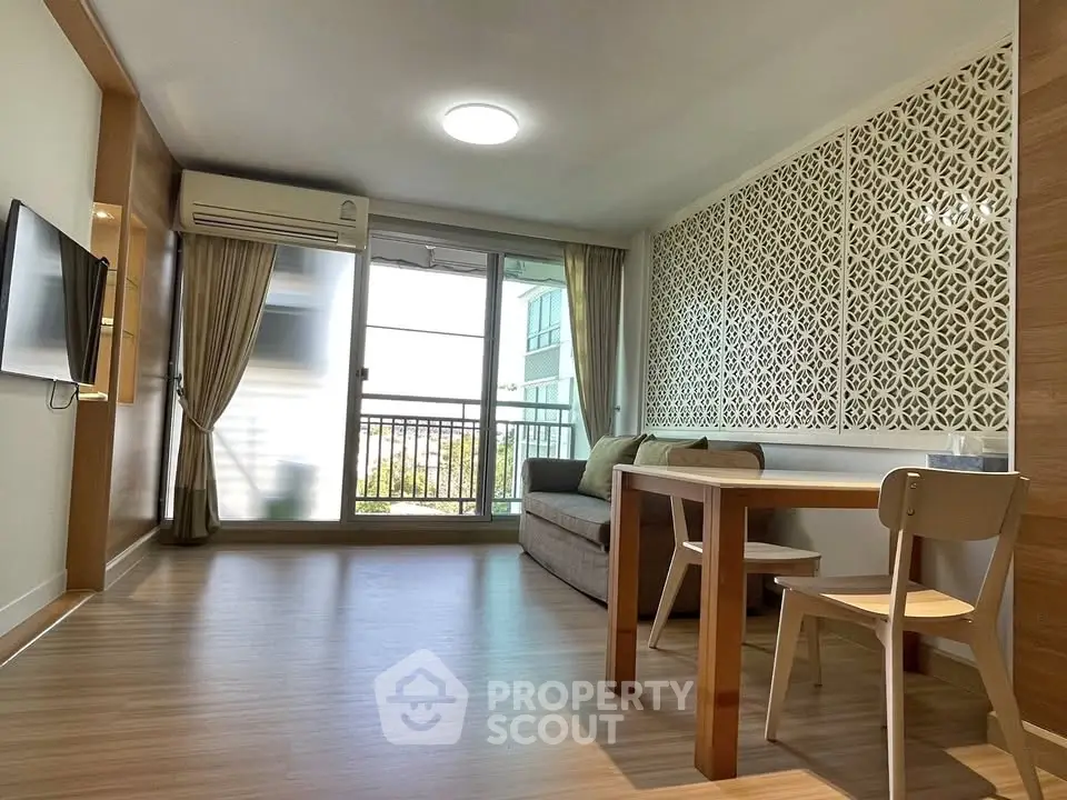 Modern living room with balcony, stylish decor, and natural light