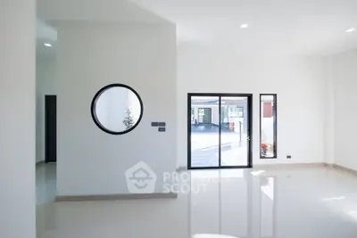 Spacious modern interior with large windows and unique circular window design.