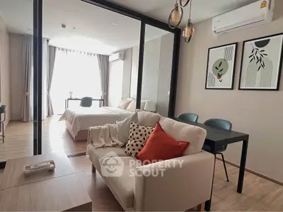 Modern open-plan living room with stylish decor and natural light in a cozy apartment.