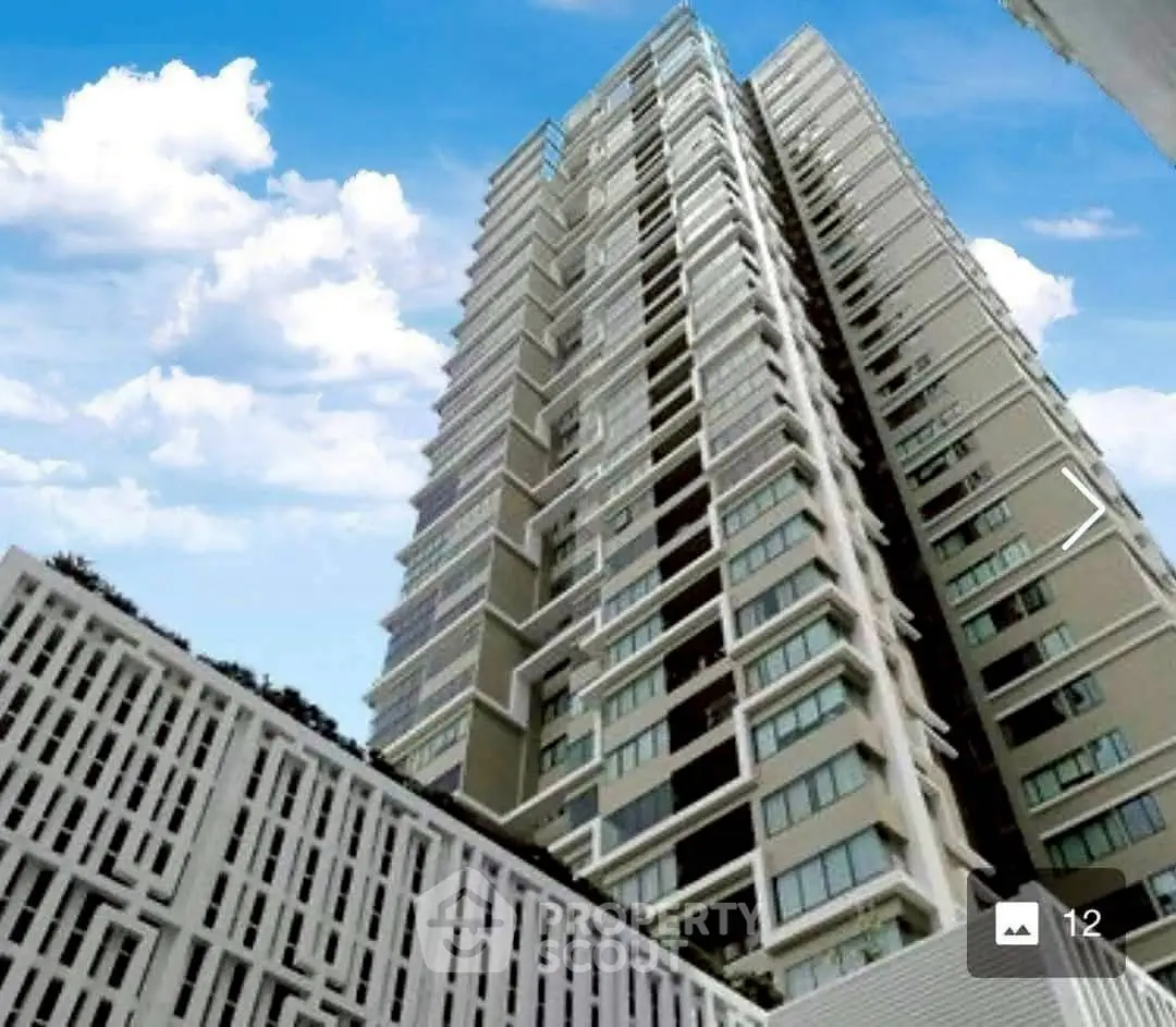 Stunning modern high-rise building with sleek architectural design against a vibrant blue sky.