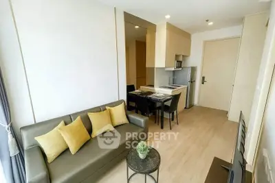 Modern living room with sleek furniture and open kitchen layout in a stylish apartment.