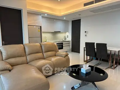 Modern living room with leather sofa and sleek kitchen in open layout apartment