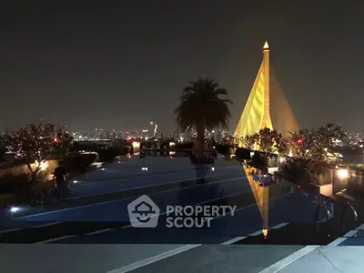 Stunning rooftop pool with city skyline view and iconic architecture at night.