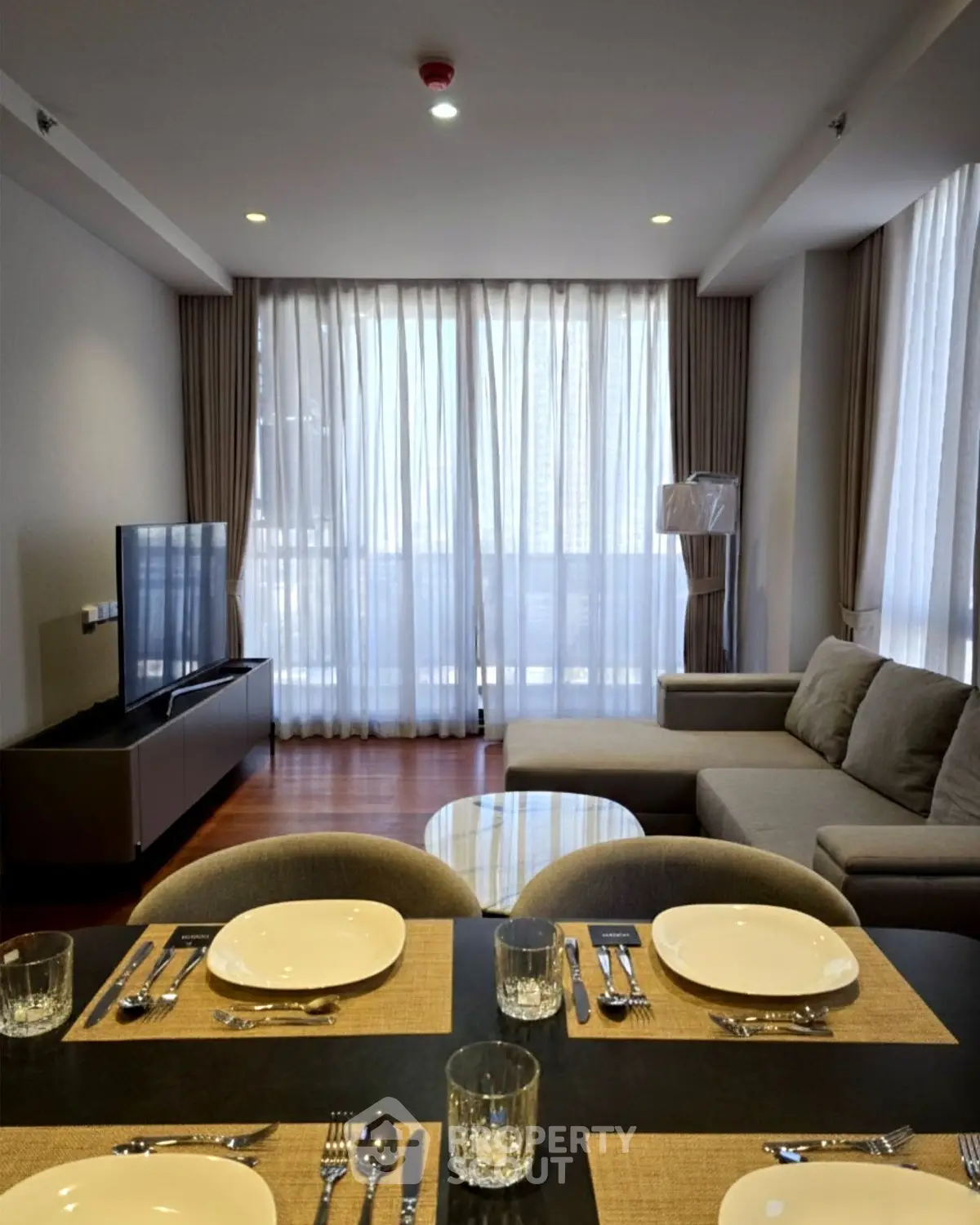 Modern living room with elegant decor and large windows in a stylish apartment.