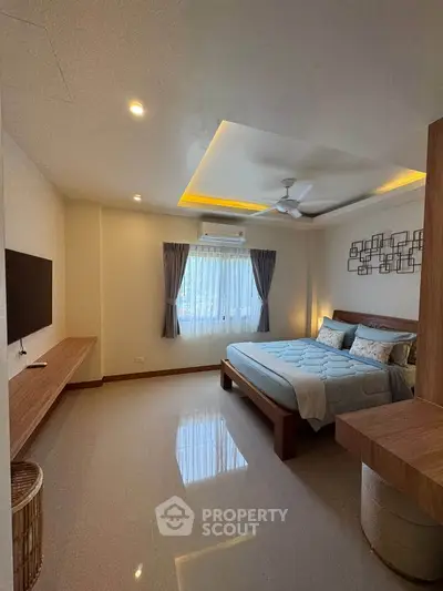 Spacious bedroom with modern decor and natural light in a stylish home.