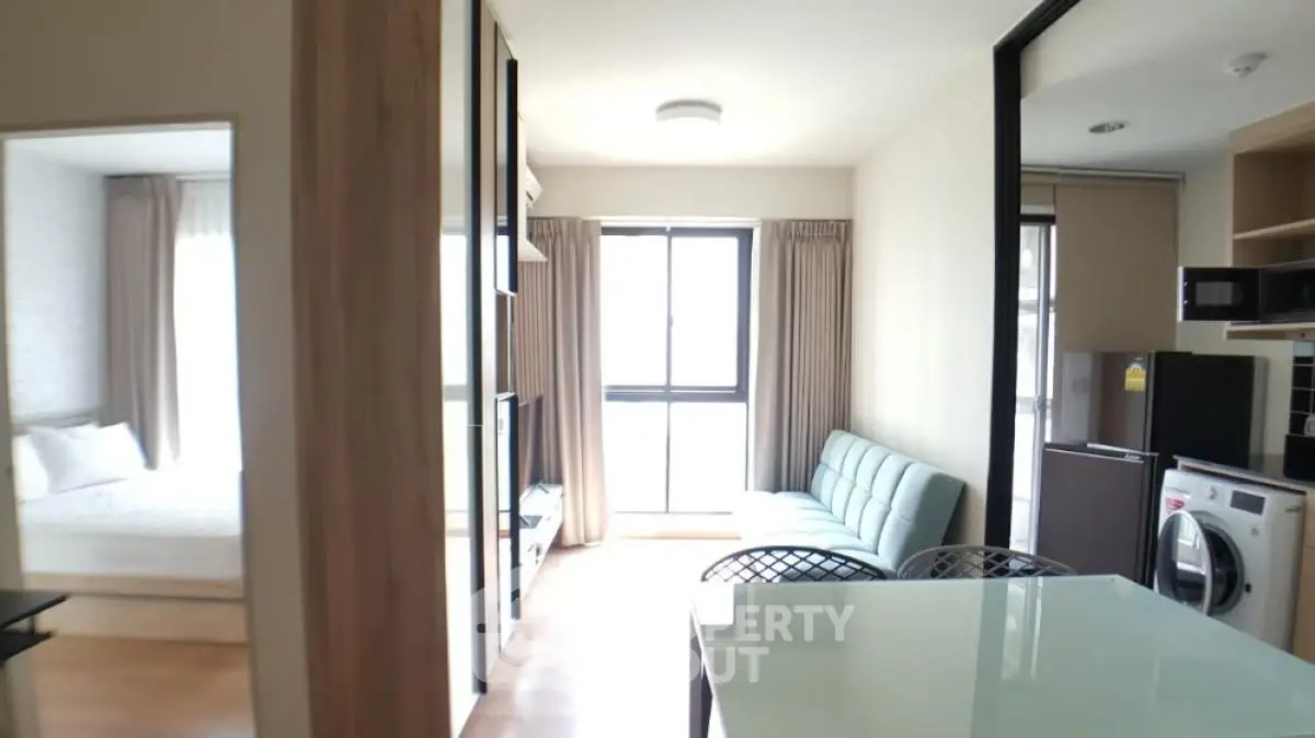 Modern apartment interior with open layout, featuring a cozy living area, kitchen, and bedroom.