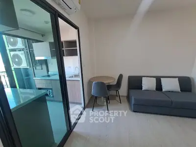 Modern living room with sleek furniture and open kitchen layout in a stylish apartment.