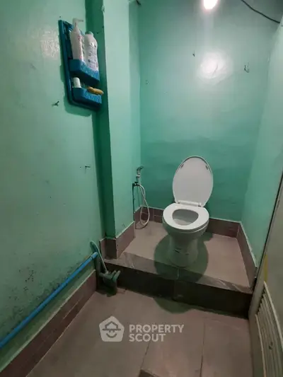 Compact bathroom with toilet and wall-mounted toiletries in a minimalist design.