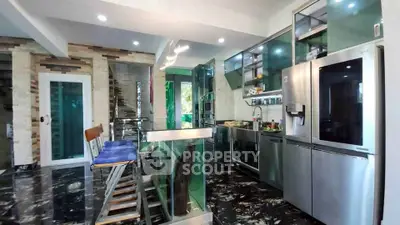Modern kitchen with sleek stainless steel appliances and stylish bar seating
