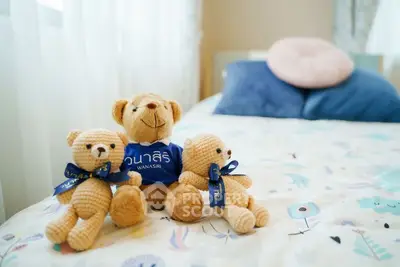 Cozy bedroom with plush teddy bears on a colorful bedspread, perfect for a child's room.