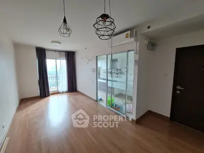 Spacious living room with modern lighting and balcony access in a contemporary apartment.