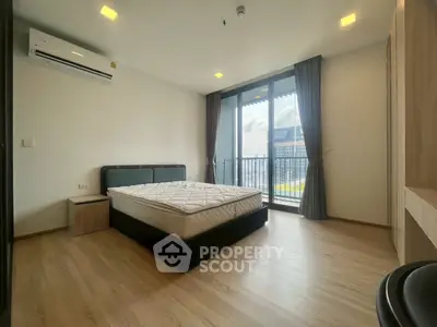 Spacious bedroom with large windows and balcony access in modern apartment