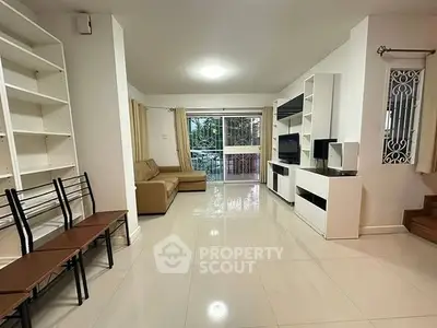 Spacious living room with modern furniture and large windows offering natural light.