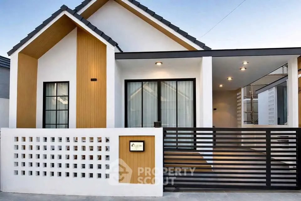 Modern minimalist house exterior with sleek design and stylish facade, featuring a gated entrance and contemporary lighting.