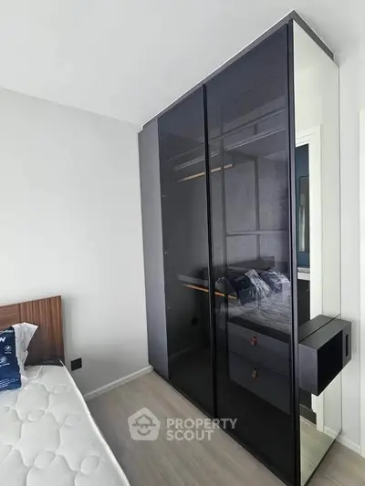Modern bedroom with sleek glass wardrobe and minimalist design