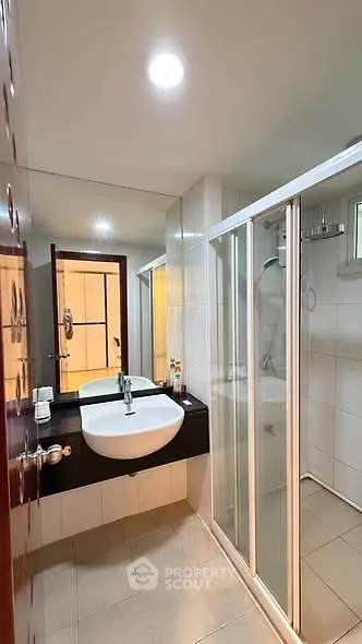 Modern bathroom with sleek shower and elegant sink in a contemporary home.