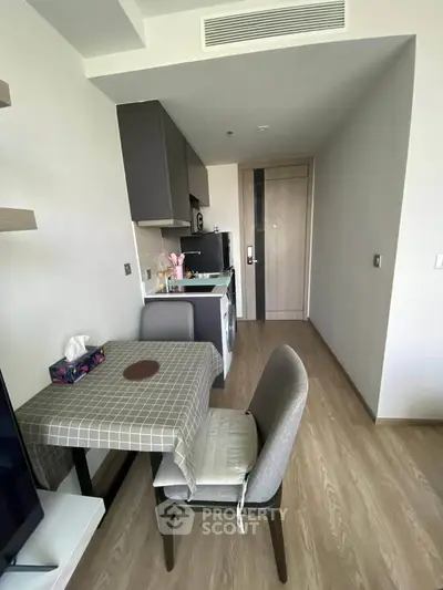 Modern compact kitchen and dining area with stylish decor and wooden flooring.