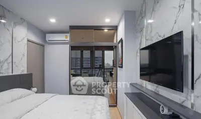 Modern bedroom with marble accents and city view, featuring a sleek TV setup and mirrored wardrobe.