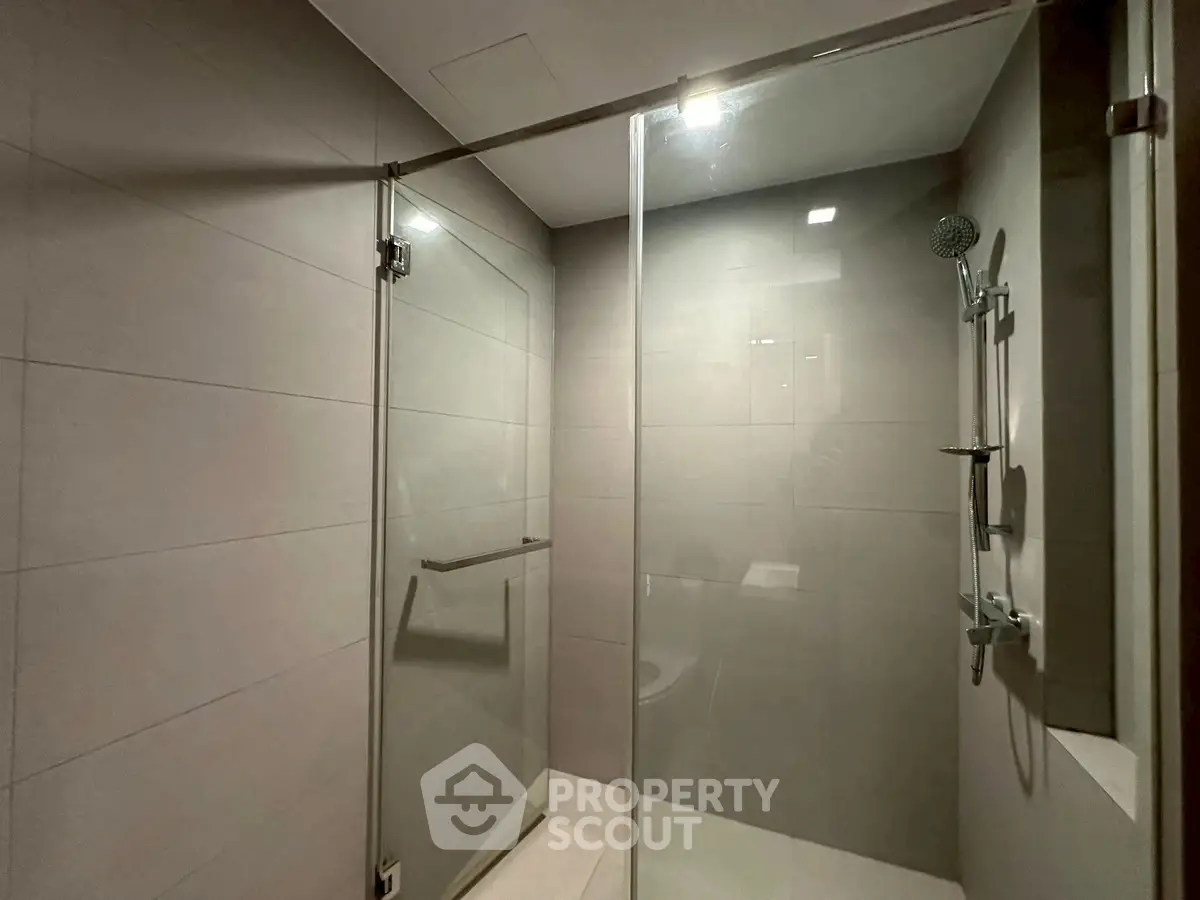 Modern bathroom with sleek glass shower enclosure and contemporary fixtures.